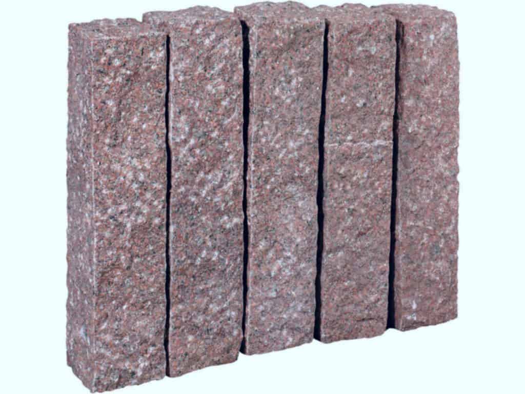 Palisade aus Granit Zora. Die grob gestockten/gespitzten Granitpalisaden sind handgearbeitet und dennoch relativ maﬂhaltig.